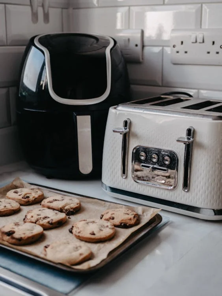 An air fryer and microwave next to some cookies