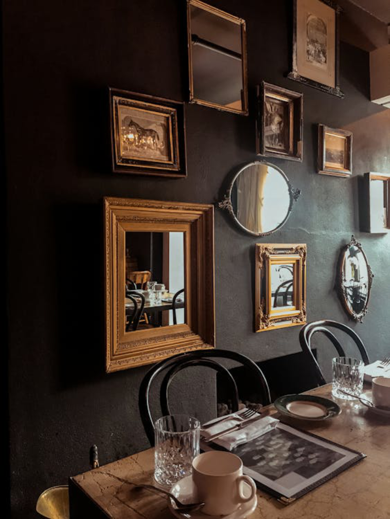  Different mirrors and frames hanging on a dining room wall