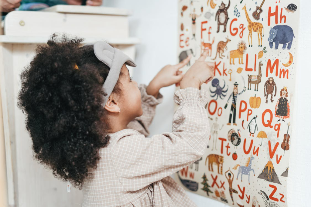  A child playing with a wall-mounted alphabets poster