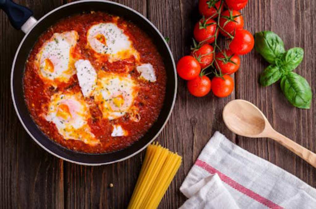 One-pot Shakshuka with noodles, basil, and tomatoes on the side