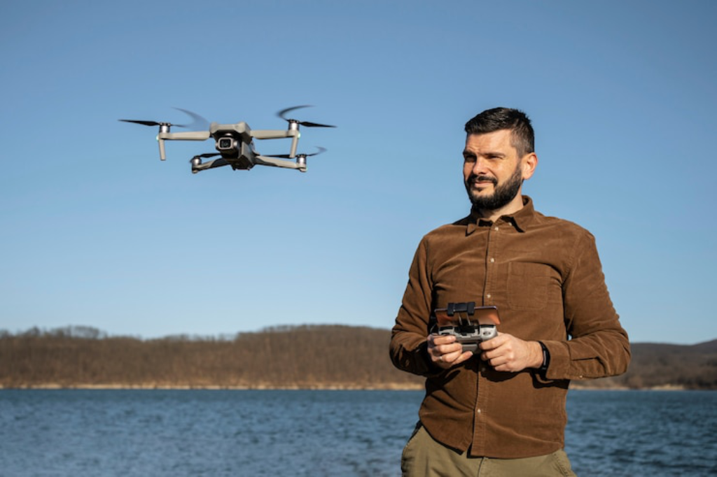 A man using a remote controller to pilot a GPS-enabled drone with a camera