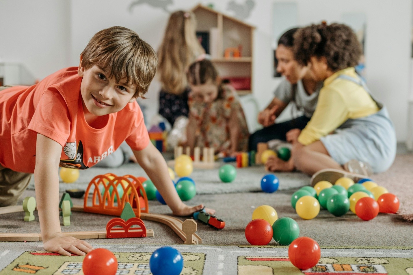 children happily playing in a play area with colorful toys