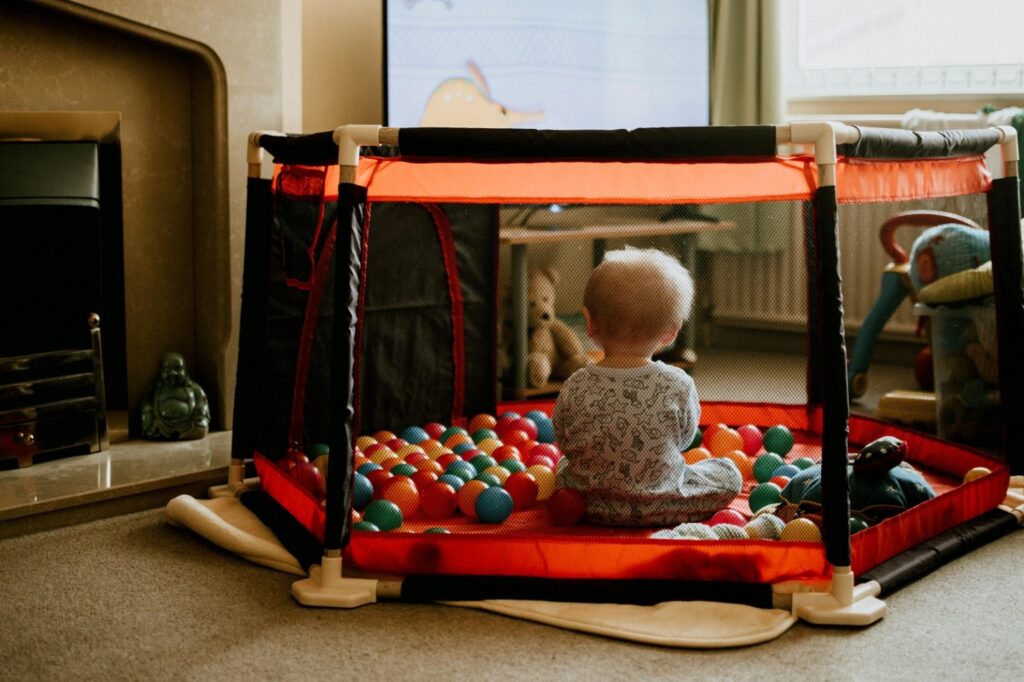 a baby playing in a playpen with balls