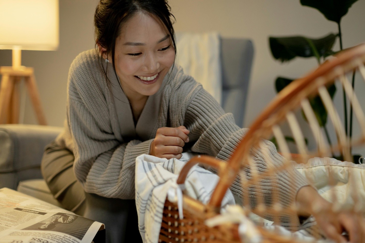 a mother playing with a child in a bassinet