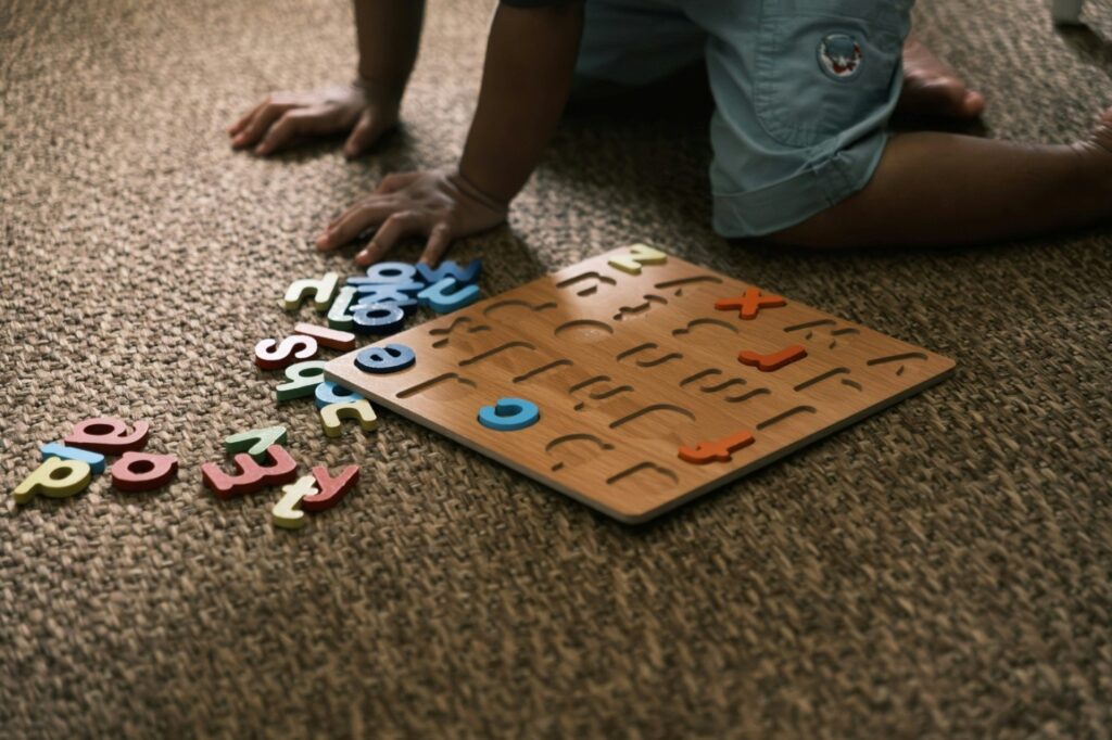 a child playing with an alphabet’s puzzle set